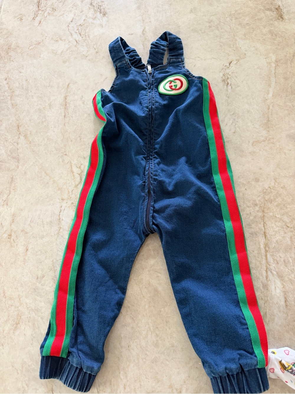 Gucci denim overalls featuring a signature logo patch and red and green side str